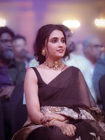 A beautiful candid shot of actress Priyanka Mohan during an awards show. The soft lighting and her relaxed posture create an elegant and thoughtful portrait.