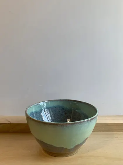 A beautiful bowl with a two-toned glaze, where a light green flows over a darker, earthy base.