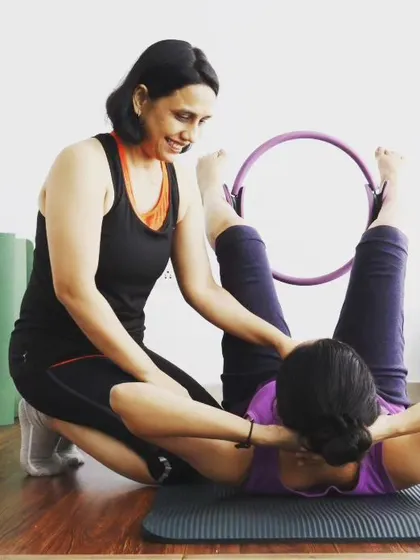 Another angle of me assisting a student with the Pilates ring. You will learn how to use various props to both assist and challenge clients, making your classes more versatile.