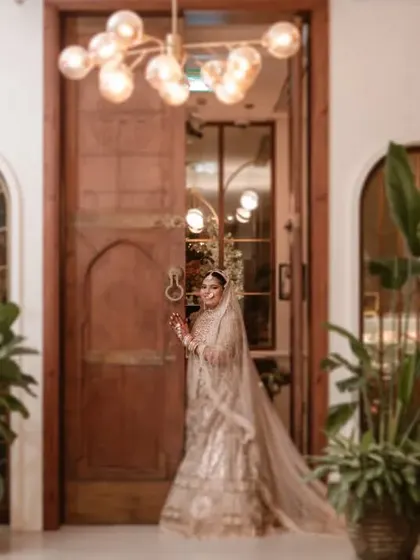 Vidhi making her entrance, a moment of anticipation as she stands at the door. The grand setting and her stunning outfit create a powerful image of a bride ready to begin her new chapter.