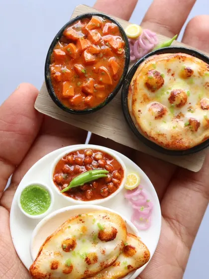 A close-up of two different naan and curry miniatures, showcasing the different styles and details I teach.