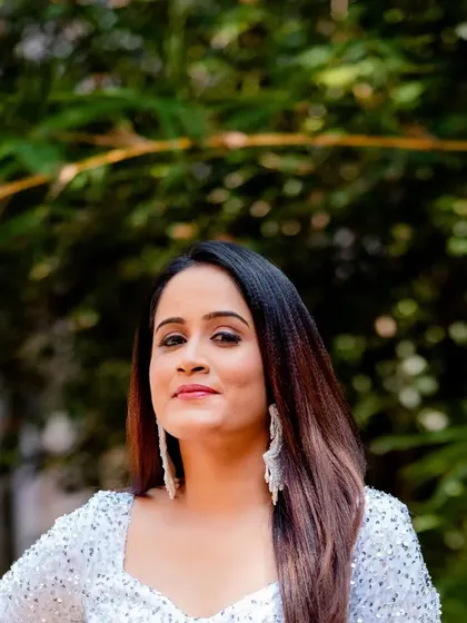 A portrait of a client in a full-sleeve white sequin gown.
