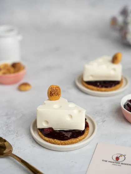 We love to have fun with our desserts. Our Wild Cherry Cheesecake is a playful twist on a classic, crafted to look like a wedge of cheese, complete with a buttery crumble base and a rich wild cherry compote filling.