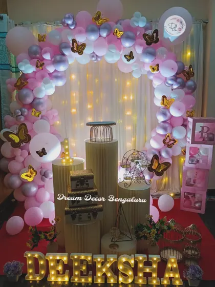 A simple yet elegant butterfly theme with a circular balloon arch and fairy lights. This setup is perfect for home celebrations or smaller venues.