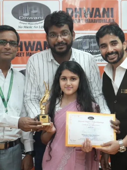 Our faculty members presenting a trophy to a talented young student.
