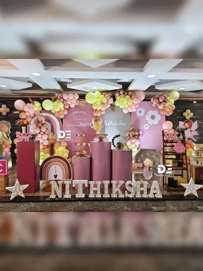 The full setup for Nithiksha's fairy-themed third birthday, showing a cohesive design with multiple elements like cake plinths, props, and a large backdrop.