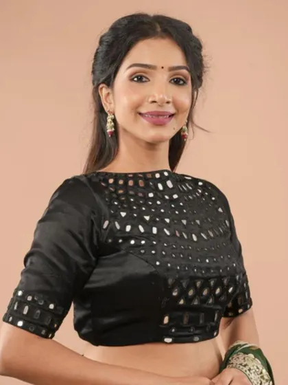 A black blouse with mirror work cutouts on the yoke and sleeves, creating a modern and edgy design.