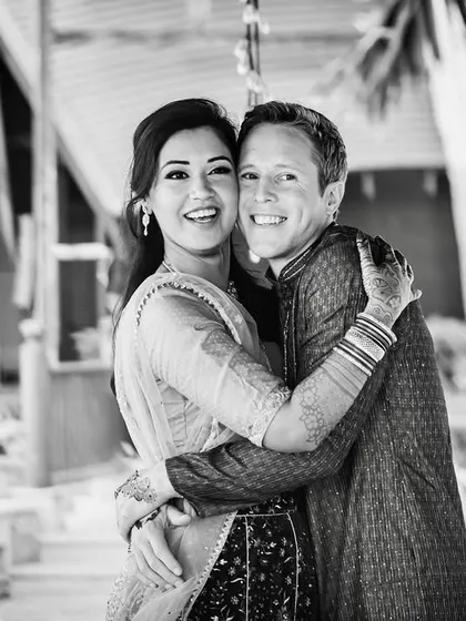 A joyful and candid couple portrait in black and white. Their bright, happy smiles are infectious and show their genuine connection.