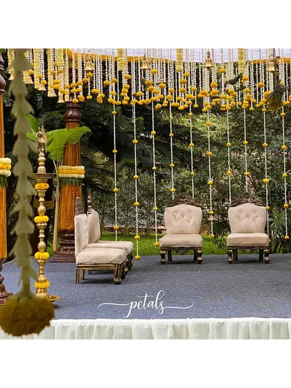 A detailed view of the mandap, highlighting the intricate floral work and the classic seating arrangement. The design is perfect for a traditional South Indian ceremony, focusing on cultural symbolism and natural beauty.