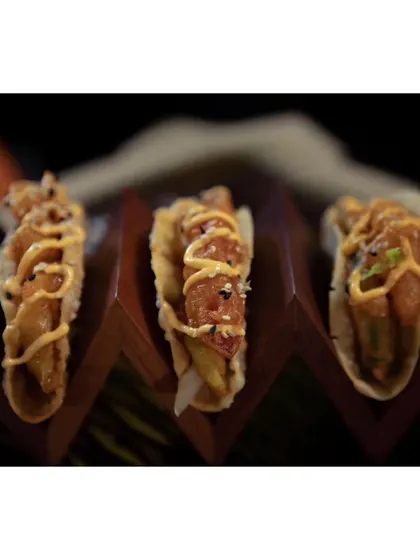 Our Korean Avocado Taco, featuring crispy fried avocado and fresh veggies in a fluffy taco shell, drizzled with a special sauce. A perfect fusion of flavors.