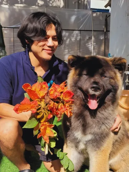 A team member with a happy Akita and a bouquet of flowers. We celebrate all the small joys.