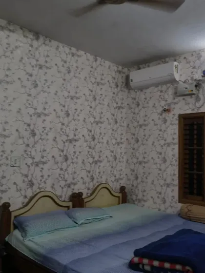 Another view of the grey branch wallpaper, showing how it looks across a larger wall with a bed.