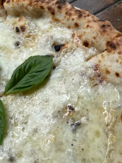 A macro shot of our Bianca Truffle pizza, showing the melted cheese and hint of truffle.