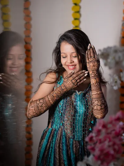 A creative portrait of the bride with her mehendi, using a reflection to add an artistic touch. It’s a unique way to capture this special pre-wedding ritual.