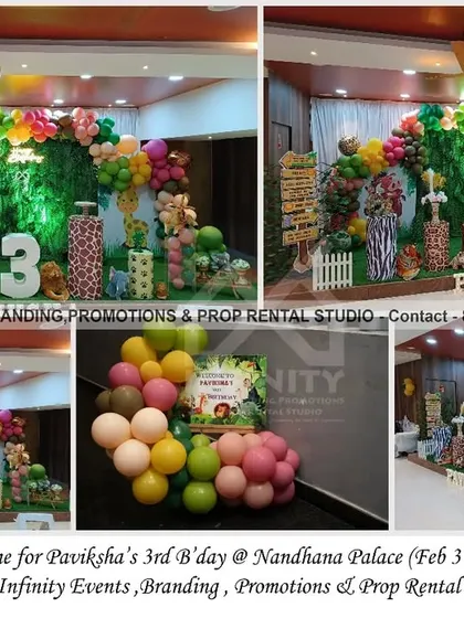A "Wild Three" safari party at Nandhana Palace. This large setup features a grass wall backdrop with a colorful balloon arch, a light-up number "3," and various animal props, creating an immersive jungle experience.