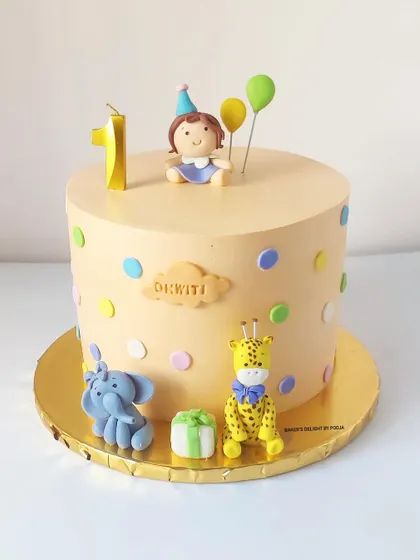 A delicate pastel cake for a first birthday, featuring a cute fondant girl, elephant, and giraffe. These handcrafted animals add a whimsical touch to the celebration.