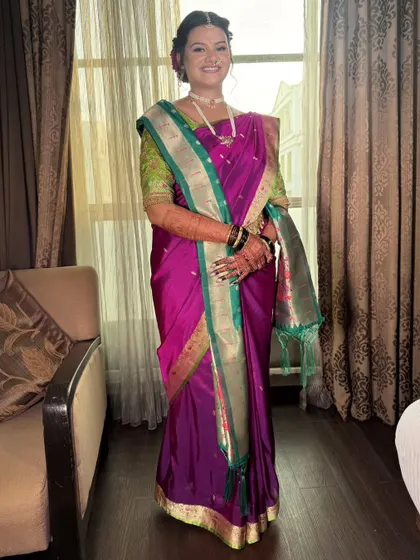 Adorned in tradition and wrapped in grace. This bride shines in a rich purple Paithani saree with a contrasting green and gold border, perfectly draped for her special day.