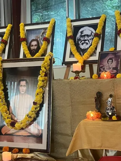 The altar prepared for our Janmashtami celebration, with portraits of the masters garlanded in yellow flowers. The altar is the visual focus that helps us to concentrate our devotional feelings.