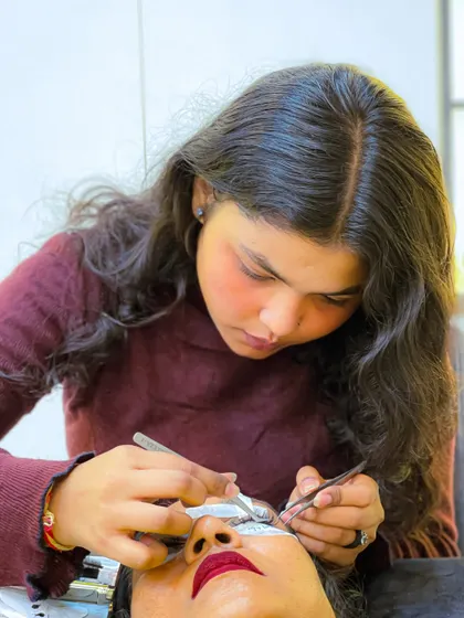 A student carefully applies lash extensions, demonstrating the steady hand and attention to detail we instill in our training. Every practice session builds confidence for real client work.