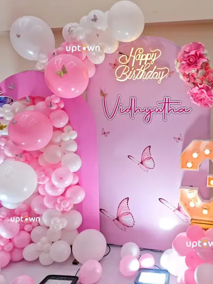 A close-up of the pink arched backdrops and the organic balloon garland.