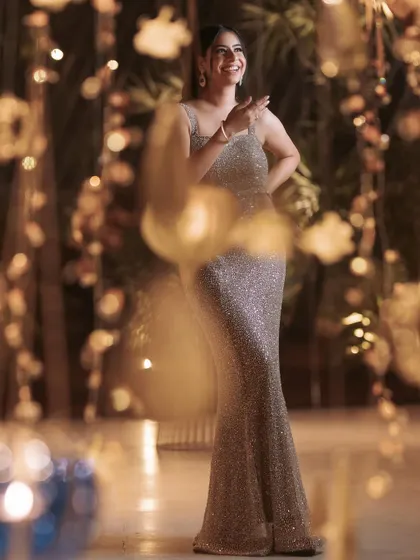 A candid, joyful shot of the client in her champagne gown. The way the sequins catch the light shows the beautiful movement and glamour of the piece.
