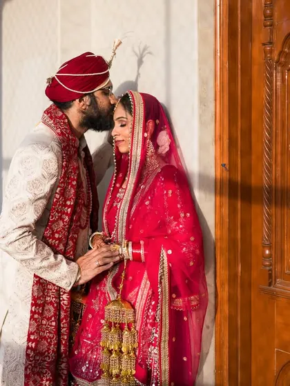 A quiet, romantic portrait of Suntej and Manjit after their Sikh wedding ceremony, the groom's kiss a gentle promise.