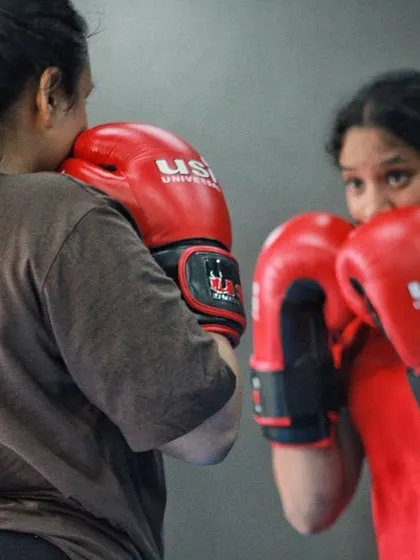 Two women practicing their guard and stance. This is a basic partner drill that builds a solid defensive foundation.