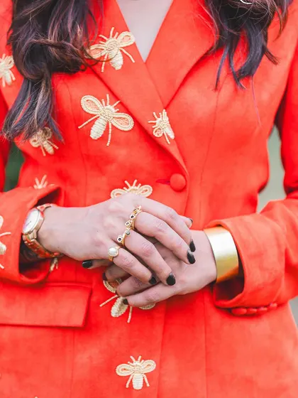 A detailed shot of the bee-you-tiful embroidery on our custom orange blazer.
