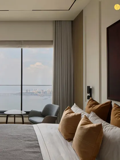 The master bedroom at 'Pad by the Bay' offers a serene escape with stunning views of the Mumbai sea link. We used autumnal tones and oak veneers to create a warm, inviting atmosphere, perfect for unwinding at the end of the day.