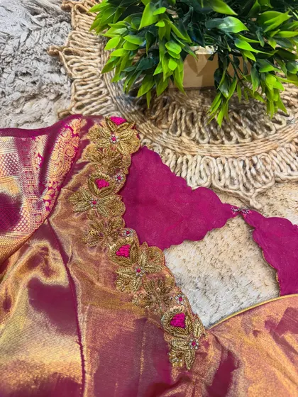 A side view of a magenta blouse, showing the detailed embroidery work along the scalloped neckline and sleeve cuffs.
