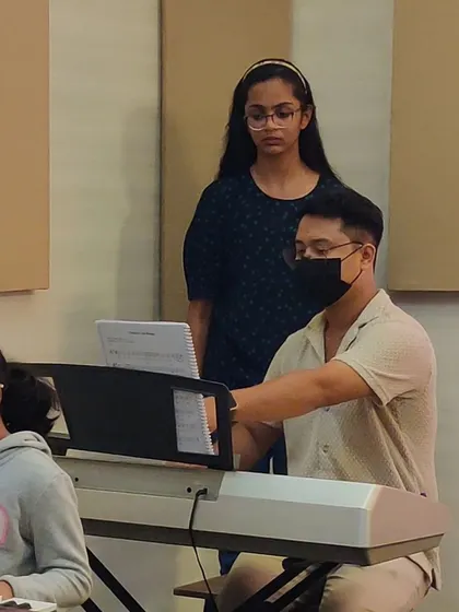 An instructor works closely with students, ensuring they understand the nuances of fingering and posture for optimal keyboard playing.