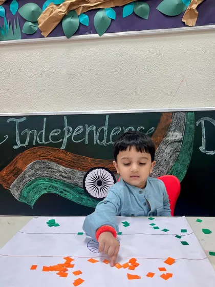 Another student meticulously works on his flag craft. These activities teach children about national symbols like the tricolor and the Ashoka Chakra in an engaging way.