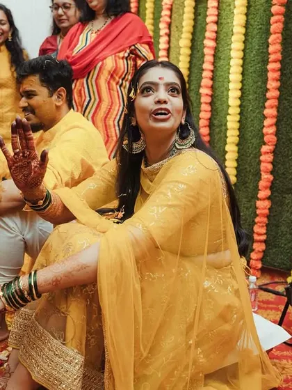 A candid moment of the bride during her Haldi, her expression full of surprise and delight.