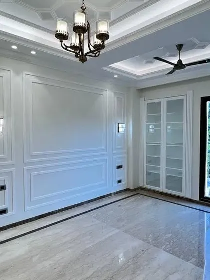 Another angle of this magnificent living room at C-257. The large windows let in ample natural light, which gleams off the polished Italian marble, and the glass-paneled cabinet adds a touch of modern elegance.