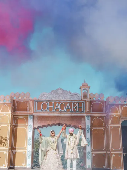 A grand, colorful shot of the couple at their Anand Karaj ceremony at Lohagarh Fort, with vibrant smoke adding a touch of modern flair to the traditional setting.