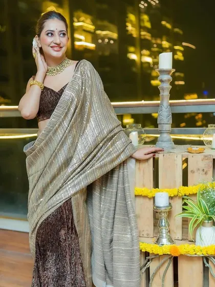 A guest enjoying a Diwali party we styled. The decor features rustic wooden crates, marigold flowers, and candles, blending traditional elements with a modern aesthetic.