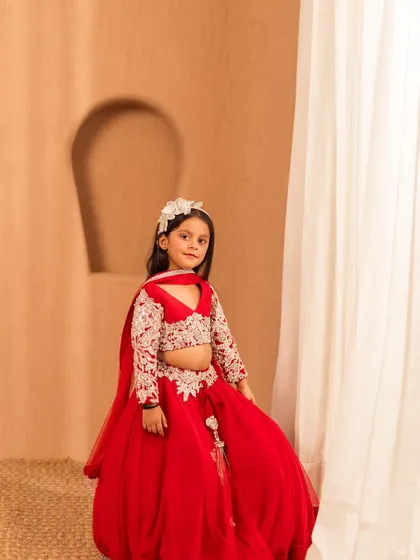 A newer design from our 2024 collection, this red lehenga features delicate white embroidery on the blouse and a voluminous skirt.