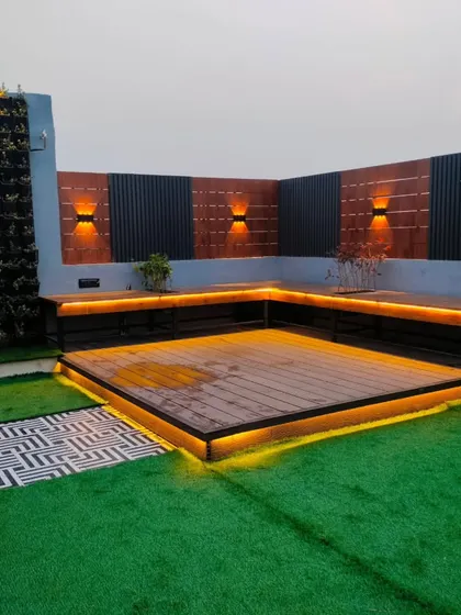 The main seating deck in the Uttam Nagar project, featuring a neon sign on a vertical garden wall.