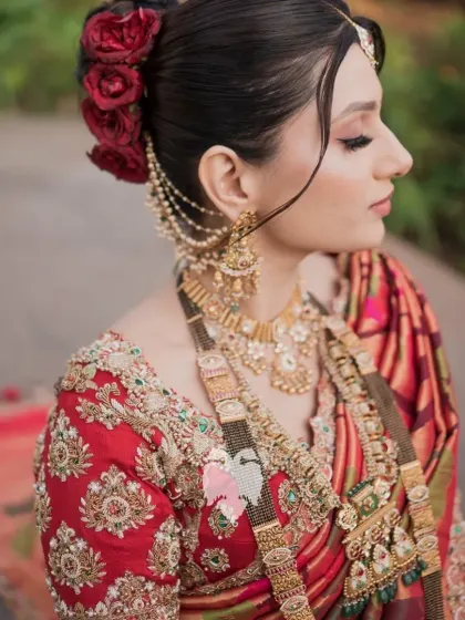 A side profile of Sophia, showing the intricate detailing on the sleeves of her red raw silk blouse.
