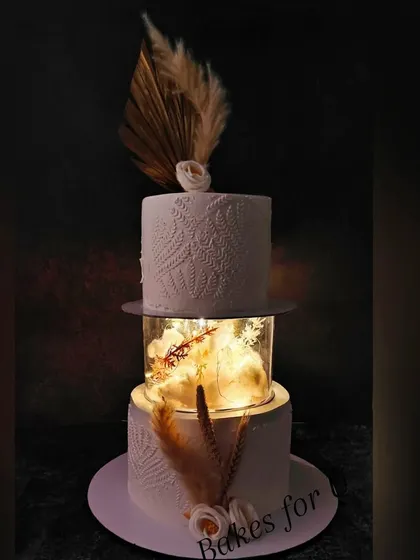 The same two-tier illuminated cake in a darker setting, showing how the lights create a magical and luxurious ambiance.