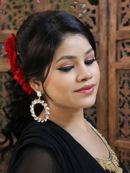 Another angle of this elegant party look, showing the soft makeup and the placement of the floral hair accessory.