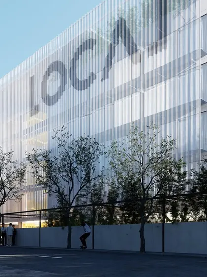 The perforated mesh screen on the facade of the co-living building allows for natural light to diffuse into the living spaces while preserving outward views from within the units.