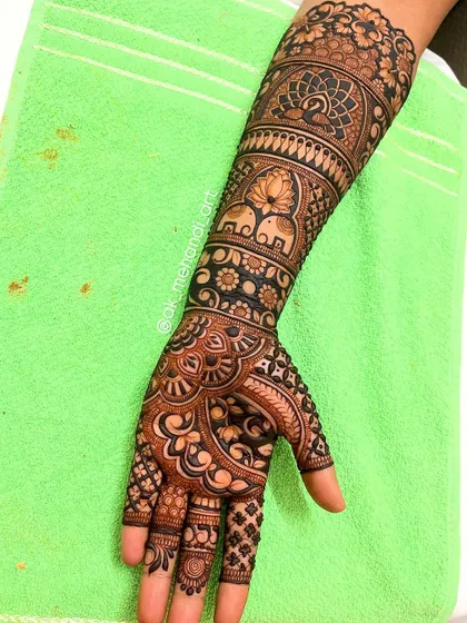 A bridal design that incorporates elephants, peacocks, and lotuses, all auspicious symbols in Indian weddings.