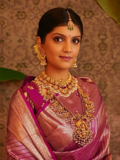 A direct portrait that captures the bride's gentle smile and the beautiful harmony of her makeup, jewellery, and traditional attire.