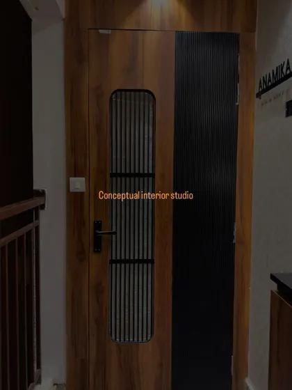 A close-up of the main door, showing the combination of wood grain laminate and a black fluted panel for a sophisticated, modern look.