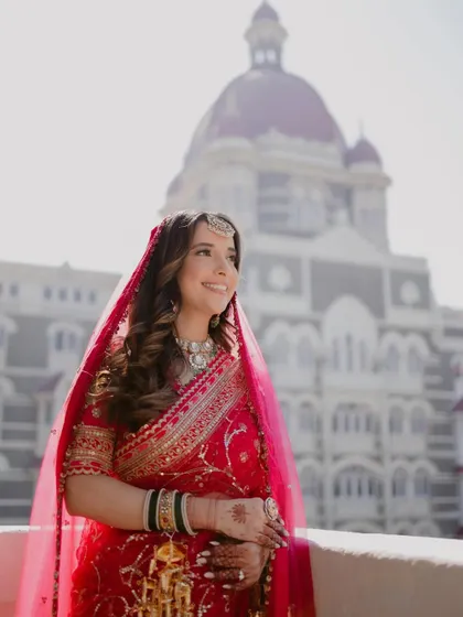A smiling bride with the iconic dome of the Taj Mahal Palace in the background. A perfect blend of personal joy and a landmark location.