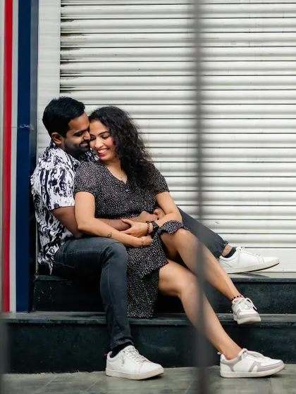 A relaxed and candid shot of the couple sitting together on city steps.