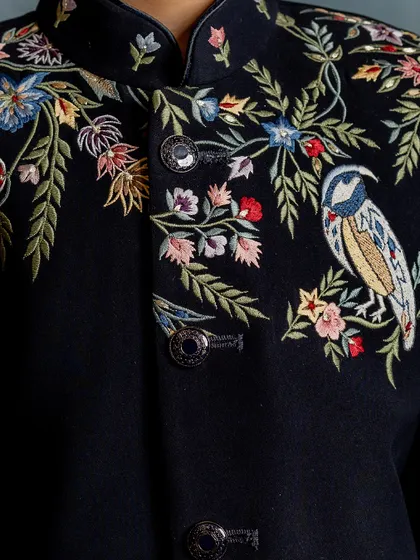 A close-up on the exquisite craftsmanship of our signature embroidered Indo-western jacket. The detail in every stitch of the bird and floral pattern is what sets our couture apart.