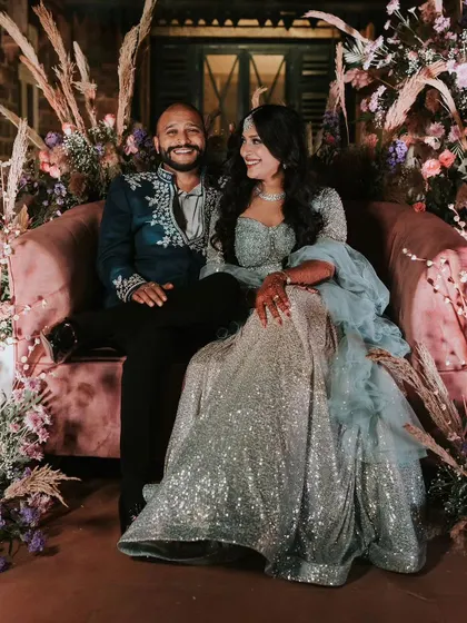 A regal portrait of the couple, seated in a beautifully decorated nook, looking every bit the king and queen of their special day.