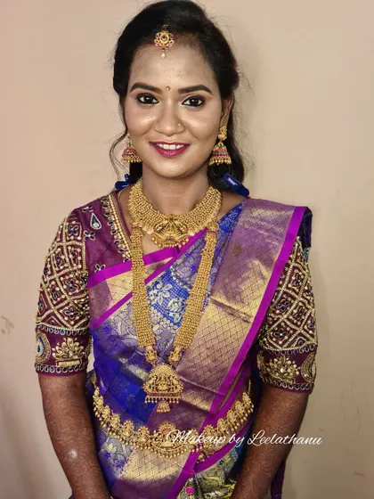 A no-filter phone click of a happy client ready for her reception. The makeup is flawless, with well-defined eyes and a smile that shows her confidence.